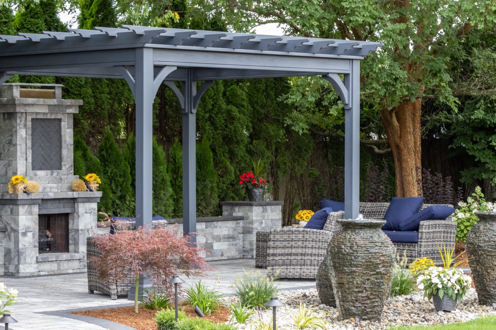 Landscape,architecture,featuring,pergola,and,stone,fireplace,with,stone,urn